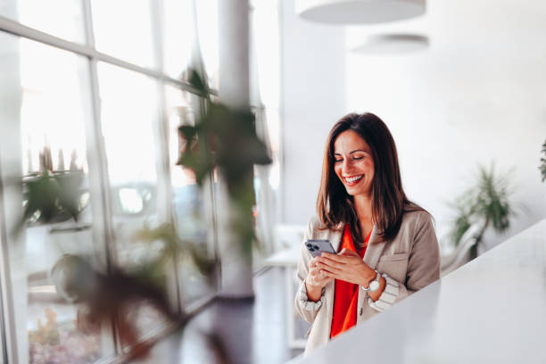 istock Smiling businesswoman using phone in office 2172654291
