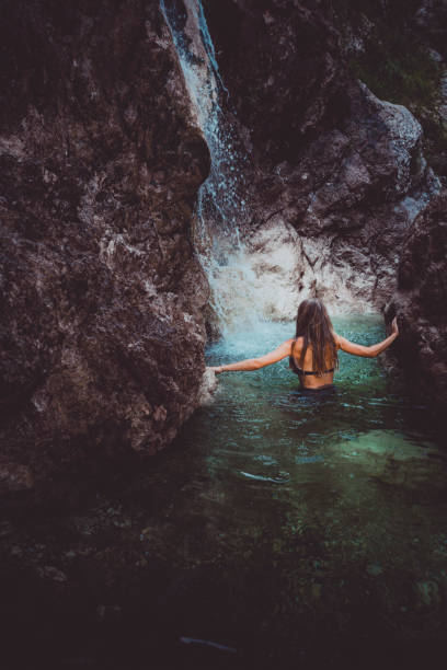 istock Young woman swims in waterfall in Soca Valley 2172667670
