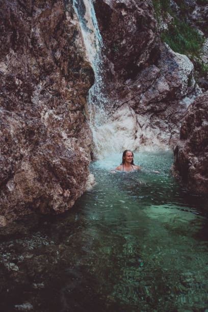 istock Young woman swims in waterfall in Soca Valley 2172667763
