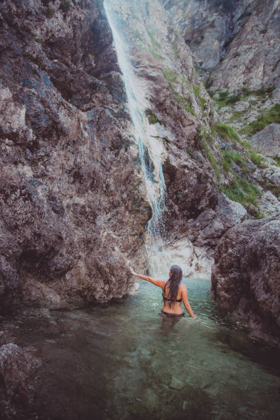istock Young woman enjoys waterfall in Soca Valley 2172667876