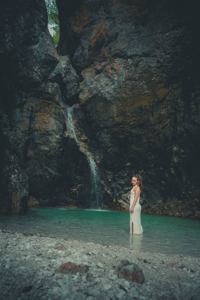 istock Young woman relaxes in pool below waterfall 2172668827