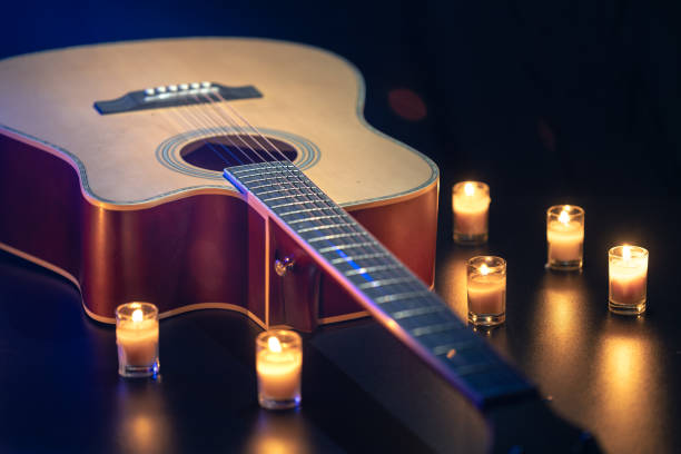 Acoustic guitar on a black background with candles. High quality photo