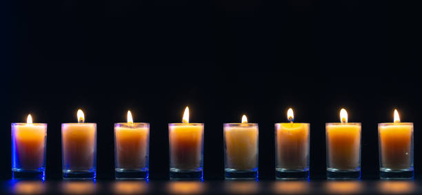 istock Burning candle on black background with backlight. Memorial Day. 2172675785