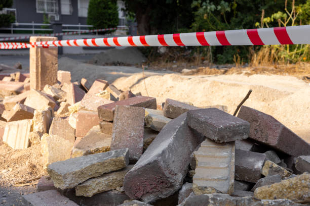 istock Construction site barrier with caution tape near piled bricks and stones at a busy urban location 2172678090