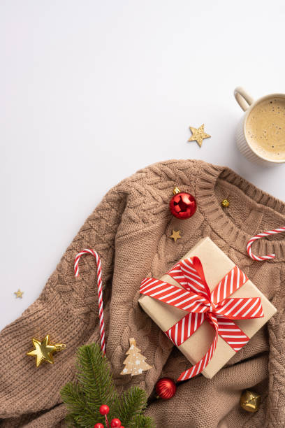 istock Cozy vertical brown sweater surrounded by festive decorations like a candy cane, wrapped gift, and holiday ornaments, creating a warm holiday atmosphere 2172678454