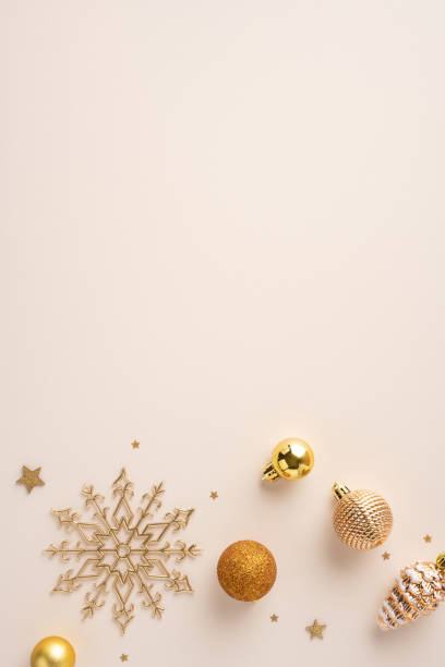 istock Festive gold Christmas vertical decorations including baubles and a snowflake on a neutral beige surface creating a sophisticated holiday atmosphere 2172678534