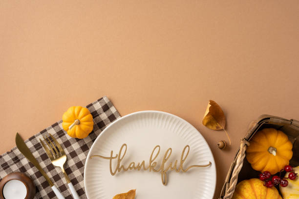 istock An elegant Thanksgiving table setting featuring a plate with the word thankful, small pumpkins, and autumn leaves, creating a warm and festive atmosphere 2172678699