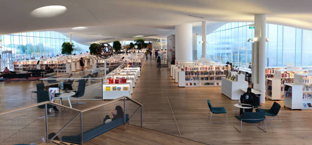 Helsinki, Finland, July 18 2024: Modern library interior is filled with natural light and people browsing or reading on a quiet afternoon. Oodi library Helsinki Finland