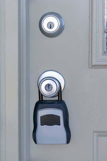Realtors Key Lock Box Hanging On Door Vertical shot of a Realtors key lock box hanging on the door of a condo for sale. real estate key lock box stock pictures, royalty-free photos & images