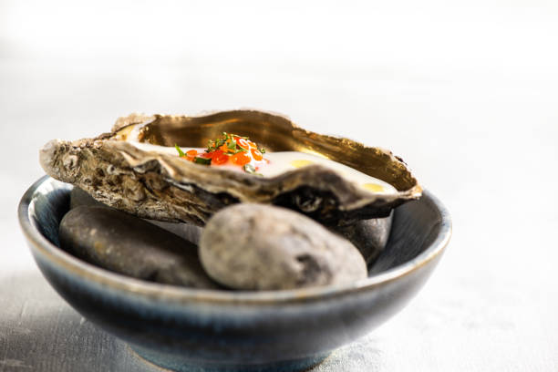 A close-up image with fresh raw half-shell oysters with vibrant seasoning