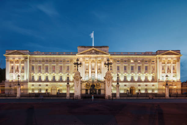 Tourist takes picture of the landmark Buckingham Palace in Westminster, London, UK in the evening.