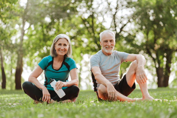 istock Senior couple smiling while relaxing in park after exercising together 2172696426