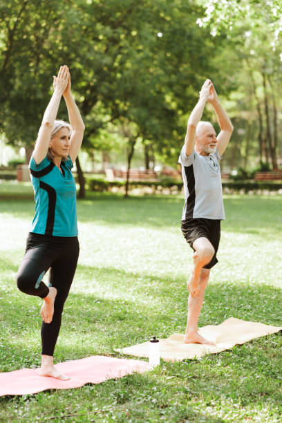 istock Senior, active couple, serious woman and man practicing yoga tree pose in park 2172696486