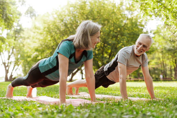 istock Senior couple doing plank exercise together outdoors in the park 2172696639