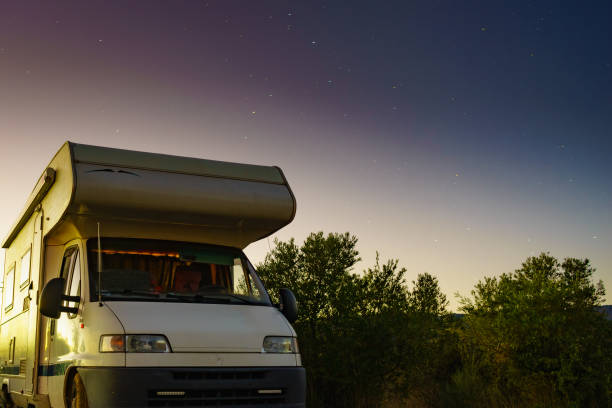 istock Night starry sky and camper rv. 2172704104