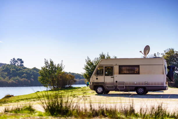 istock Caravan camping on lake shore with satellite dish on roof 2172705703