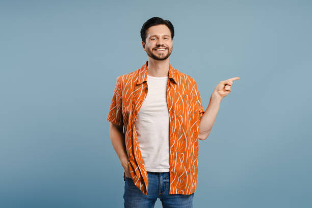 istock Smiling, handsome man pointing aside with finger posing isolated on blue background 2172705908