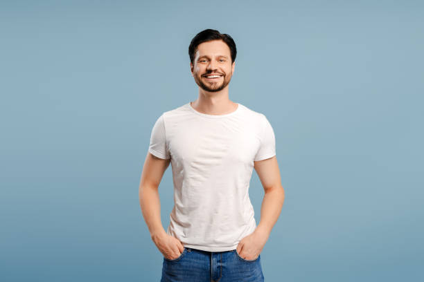 istock Attractive young man smiling with hands in pockets on blue background 2172705952