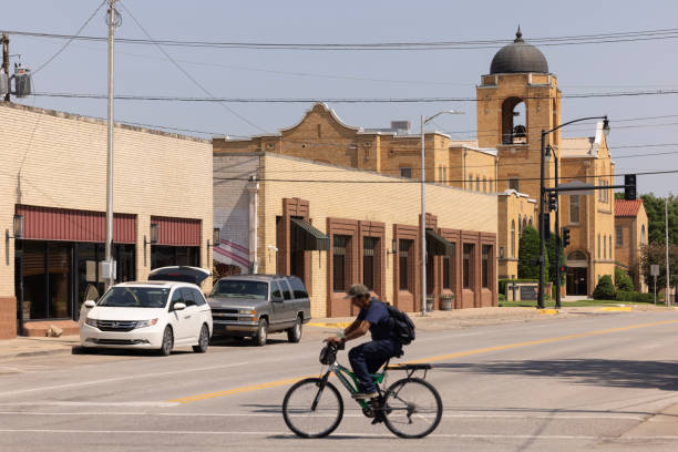 Photograph of the Spirit of Detroit sculpture in Detroit, MI created by Marshall Fredericks in 1955 from down the street with a bicyclist crossing in the foreground.
