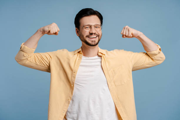 istock Happy, smiling bearded man showing muscles posing on blue background 2172707491