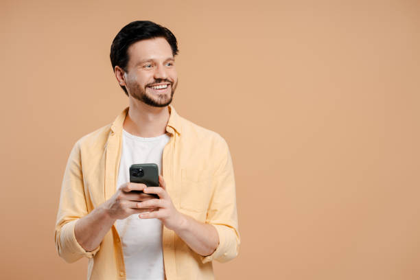 istock Smiling young man using mobile phone app for online shopping, looking away on copy space 2172707746