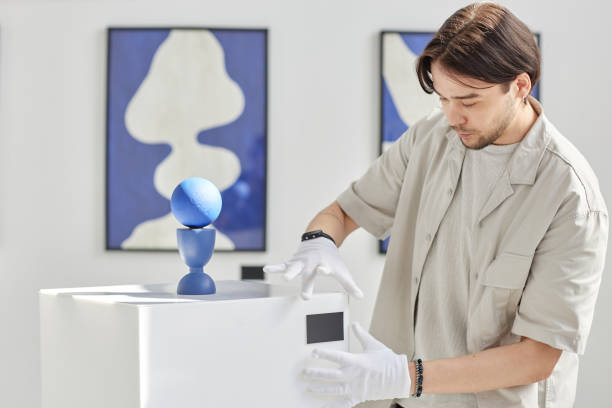 Asian Man as Art Curator Setting Up Art Gallery