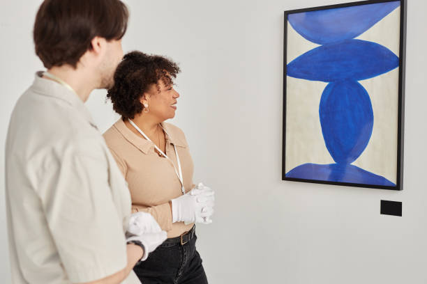 istock Two Art Gallery Workers Looking at Paintings 2172726793