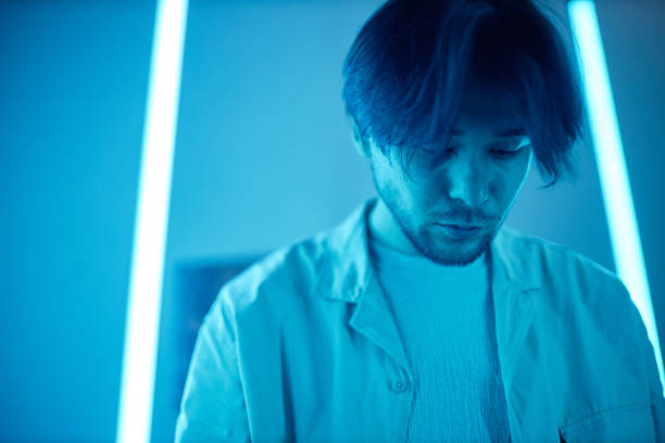 istock Asian Man in Room with Blue Neon Lights 2172727151