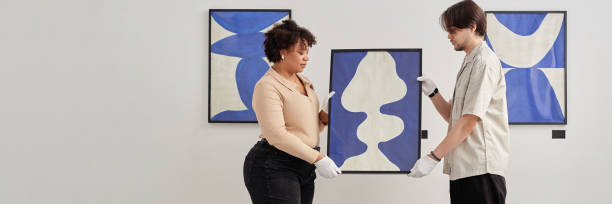 istock Header Image of Two People Holding Painting Planning Exhibition 2172727174