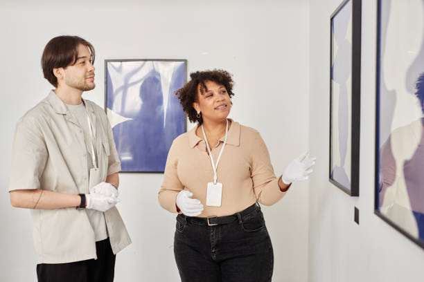 istock Woman as Art Curator Pointing at Paintings 2172727189