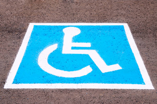 Blue and white handicap parking sign painted on an asphalt surface. A parking space reserved for individuals with disabilities.