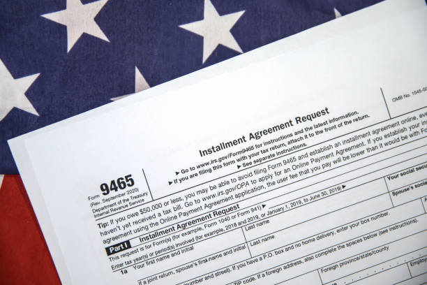 istock USA installment agreement request form paper placed on the American flag with copy space, background 2172731741