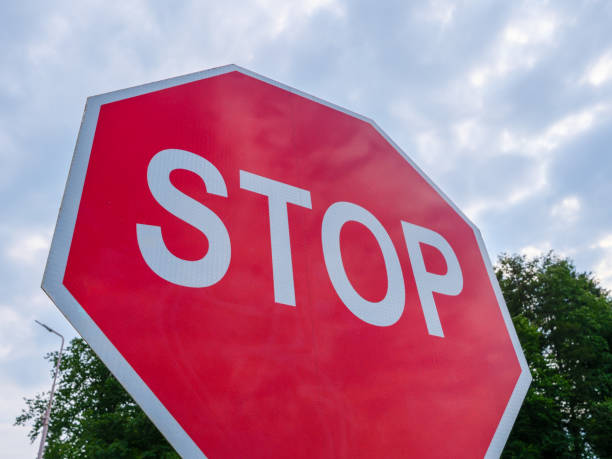 istock Red octagonal stop sign under a cloudy sky in a residential area 2172735478