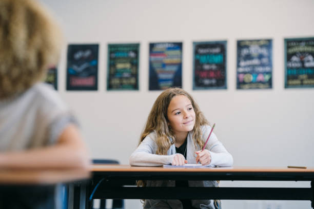 istock Elementary age girl working on writing assignment in school 2172736833