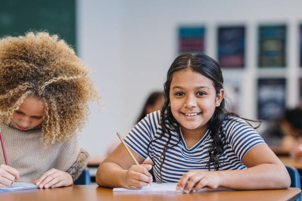 istock Two middle school girls work on classwork together 2172736846