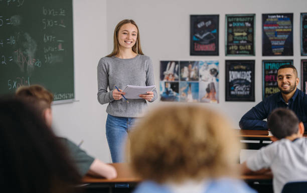 istock Middle school girl stands in class to do a presentation 2172736875