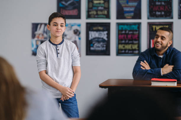 istock Middle school boy stands in class to do a presentation 2172736885