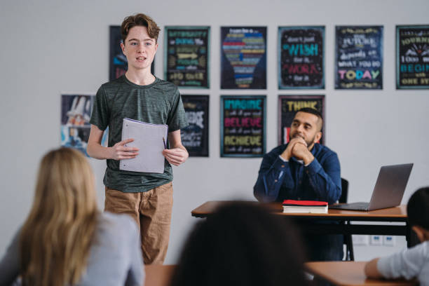 Middle school boy stands in class to do a presentation