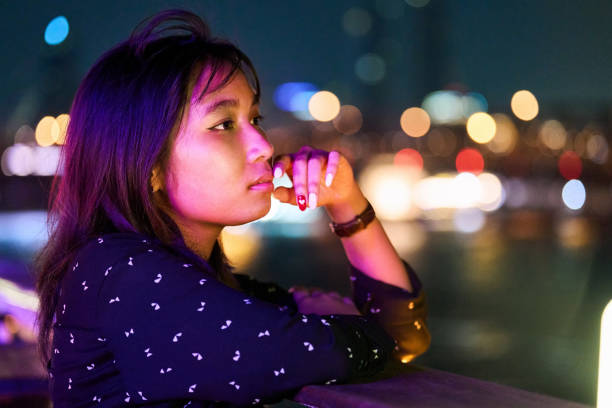 istock Thoughtful young woman on a riverfront deck at night 2172738811