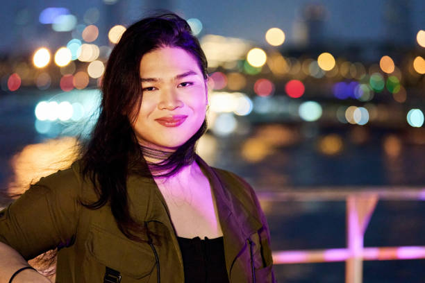 istock Confident woman standing by riverfront cafe deck at night 2172738911