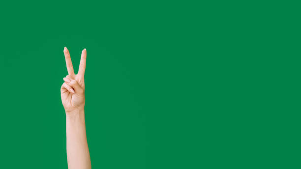 istock Peace gesture v sign hand two fingers up on green 2172743857