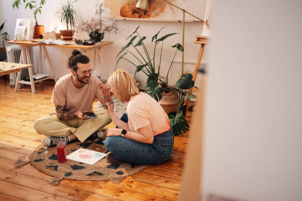 istock Artistic man having fun at atelier with girlfriend while sitting on floor 2172744519