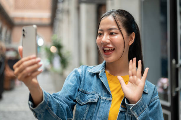 istock A charming Asian woman is talking on a video call with a smartphone while strolling through the city 2172763901