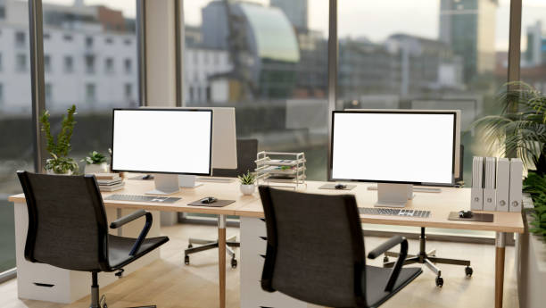 istock A modern office in a skyscraper features computer desks, positioned by the windows for a city view. 2172764097
