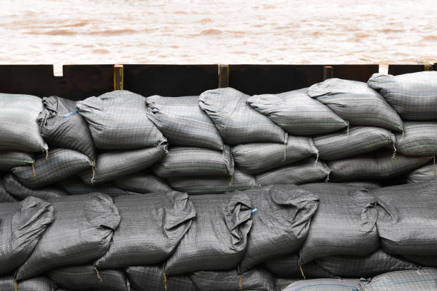 a pile of black bags on a sandy beach