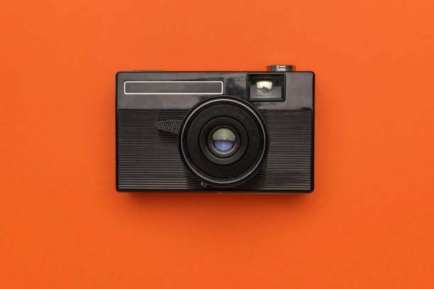 istock Vintage Black Camera on Vibrant Orange Background 2172770066