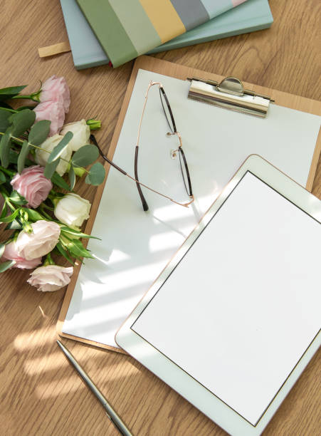 istock Stationery workspace with a blank tablet, notebook, and flowers on a wooden table, perfect for creative planning in natural light 2172777544