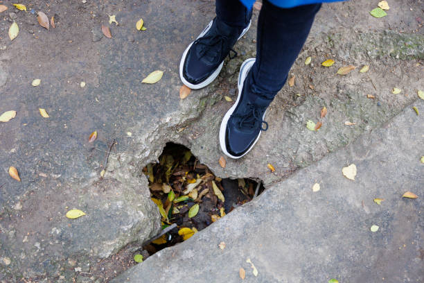 istock A person is standing on a sidewalk with leaves on the ground 2172778854