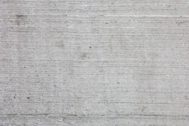 A grey concrete wall with a few cracks and a few lines. The wall is very plain and has no decoration