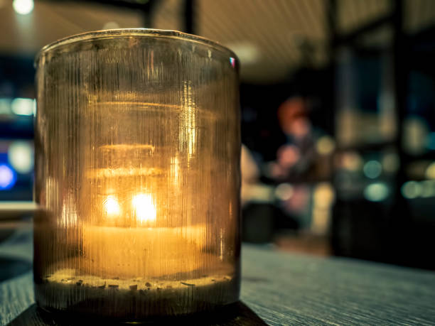 Tealight candle in glass jar on a dinning table